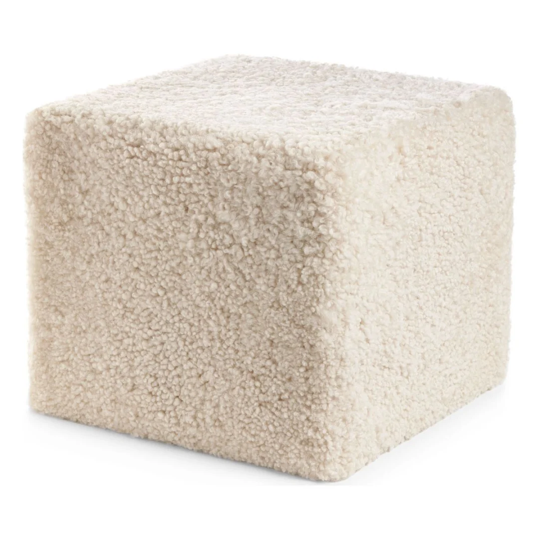 De Poef Schapenvacht Krullend Korte Wol M06 is een zachte, kubusvormige voetenbank bekleed met luxe crèmekleurige sherpa stof.