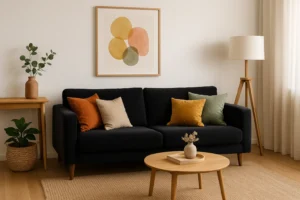 Een moderne woonkamer met een donkere bank, kleurrijke kussens en een geweven vloerkleed biedt inspiratie voor "Wat kan ik mooi combineren" met texturen en kleuren-van de ronde salontafel tot abstracte muurkunst en gezellige inrichting.