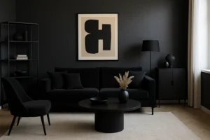 Een moderne woonkamer met zwarte muren, een zwarte bank, stoel en meubels - een bewijs dat zijn zwarte meubels in 2025 nog steeds trendy zijn - plus een ronde salontafel, minimalistische inrichting, abstracte muurkunst, een beige vloerkleed en natuurlijk licht van rechts.