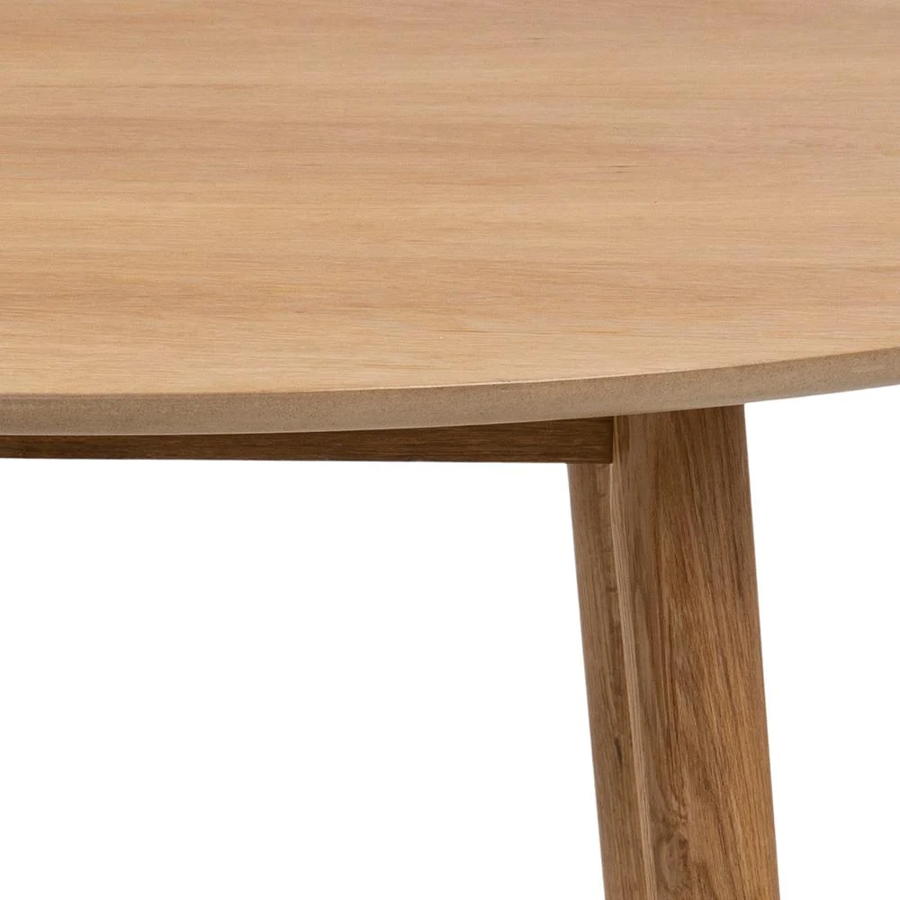 Close-up van de Eettafel Nagano 120 CM Rond Eikenhout, met een deel van het ronde eiken tafelblad en een schuine poot, die de gladde natuurlijke houtnerf en het minimalistische moderne ontwerp laat zien.