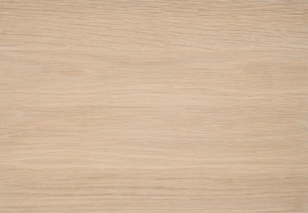 De Salontafel Wit 60 x 42 CM Rond heeft een licht eikenfineer oppervlak met een natuurlijke horizontale nerf, wat een glad en strak uiterlijk geeft en ideaal is voor tafelbladen of vloeren.
