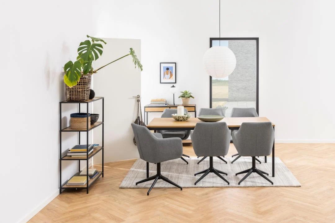 Een moderne eetkamer met een houten tafel, vier grijze stoelen, een witte hanglamp, de Seaford boekenkast met decorstukken, een potplant, ingelijste kunst op een witte muur, een lichthouten vloer en een groot raam.
