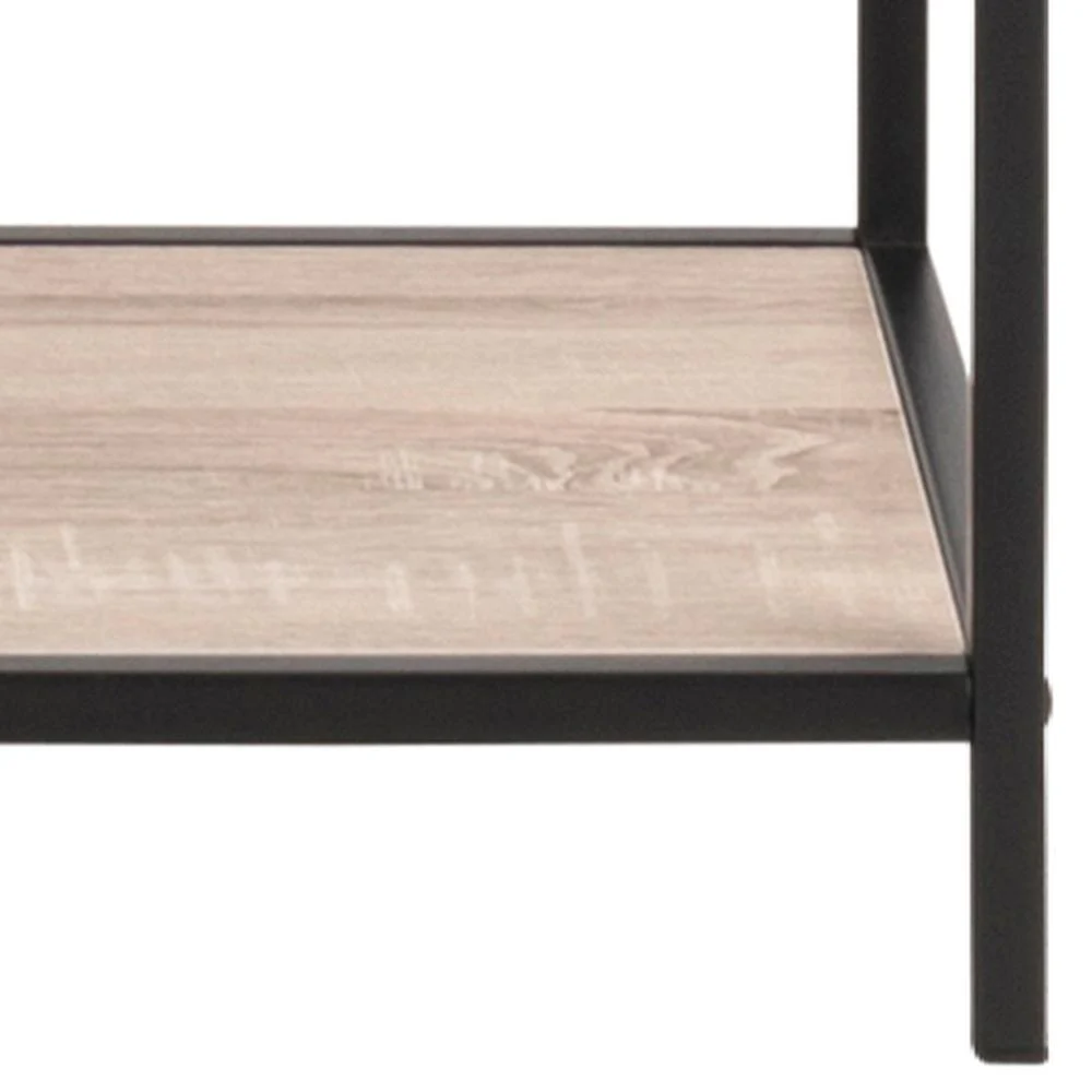 Een close-up van de onderste plank van de Seaford boekenkast, met het lichte houten oppervlak en de zwarte metalen poten en het frame.