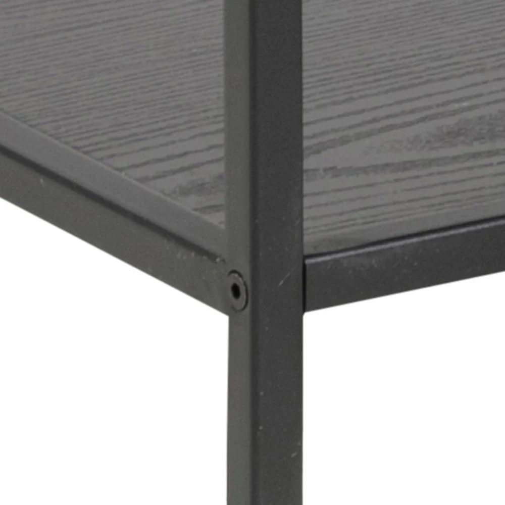 Close-up van de hoek van het zwarte metalen frame van de Seaford boekenkast, met de nadruk op de naad waar twee horizontale planken met donkere houtnerfstructuur samenkomen met de verticale steun.