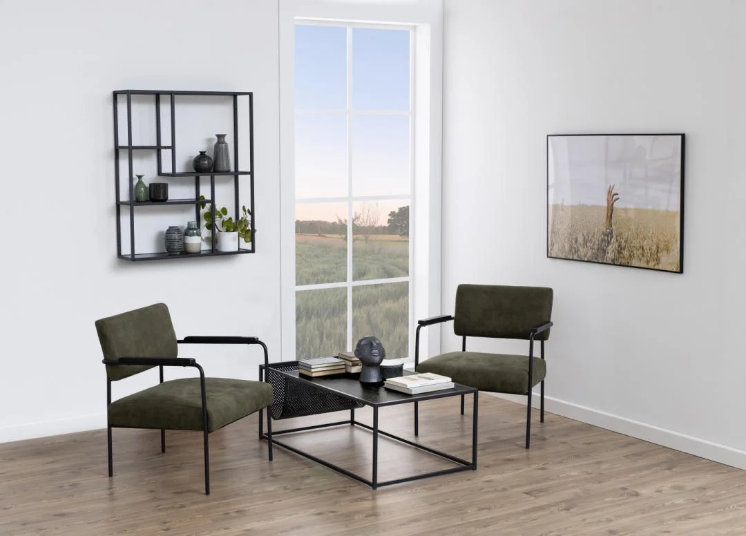 Een moderne woonkamer met twee groene fauteuils, een Salontafel Zwart 60 x 40 CM Rechthoek in mat zwart, een wandplank met decor, ingelijste foto, groot raam met uitzicht op een schilderachtig veld, lichte muren en een houten vloer.