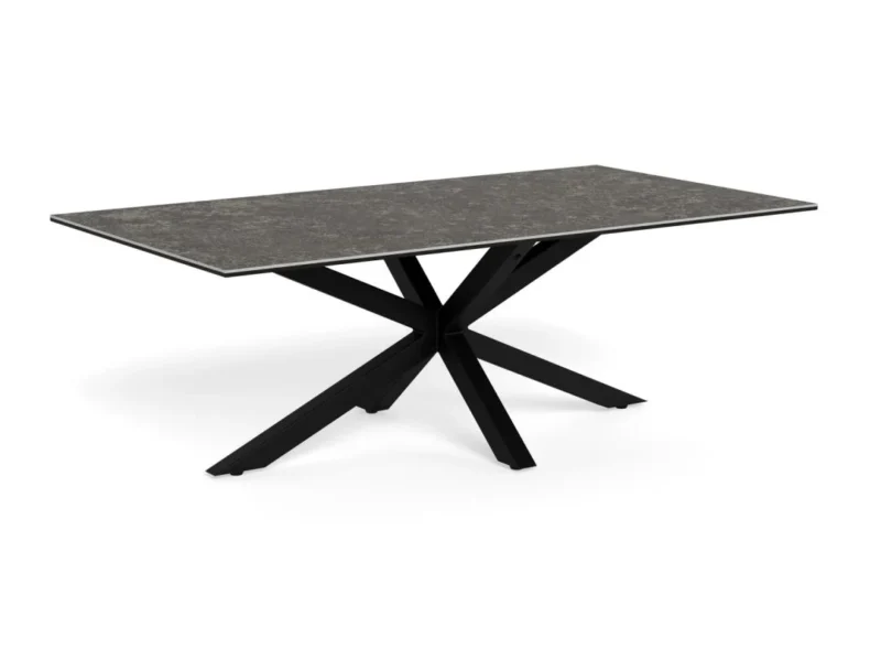 De Salontafel Zwart 130 x 70 CM Rechthoek heeft een rechthoekig blad van keramiek met een donkere, steenachtige afwerking en zwarte metalen poten die een geometrisch stervormig onderstel vormen.