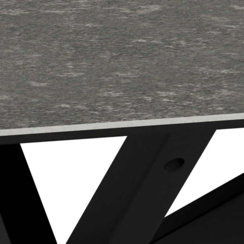 Close-up van Salontafel Zwart 130 x 70 CM Rechthoek: toont een grijs, gestructureerd keramiek tafelblad met afgeschuinde rand en zwarte metalen poten die elkaar eronder kruisen, tegen een witte achtergrond.