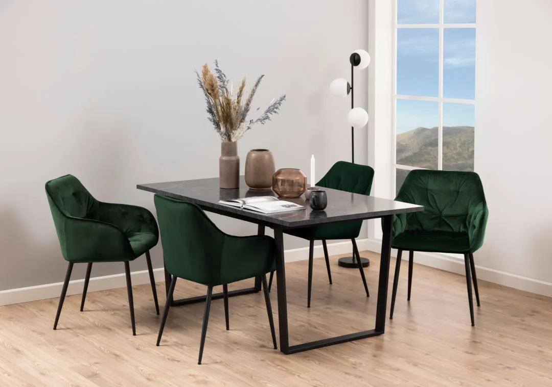 In een moderne eethoek staat de Eettafel Nieuwe Sfeer 160 x 90 CM - een elegante rechthoekige tafel van zwart marmer en staal - in combinatie met vier stoelen van groen fluweel, decoratieve vazen, een lamp met drie lampen en uitzicht op de bergen, allemaal op een lichte houten vloer.
