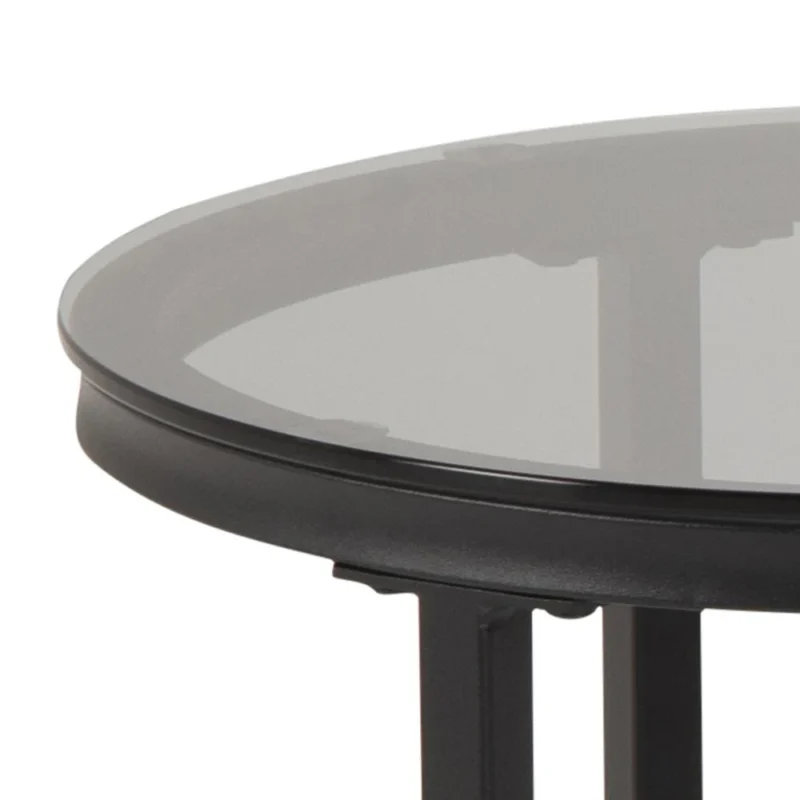 Een close-up van de rand van de Salontafel Rookglas, een ronde zwarte tafel met een blad van gerookt glas en een plastic frame.