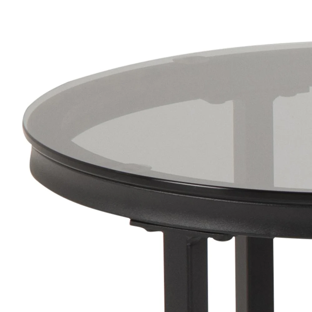 Een close-up van de rand van de Salontafel Rookglas, een ronde zwarte tafel met een blad van gerookt glas en een plastic frame.