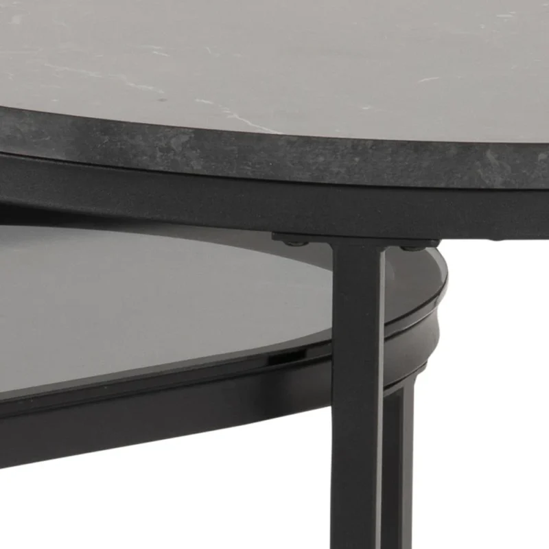 Close-up van de Salontafel Rookglas, een moderne ronde zwarte tafel gemaakt van kunststof, met een bijpassende onderplank onder het tafelblad.