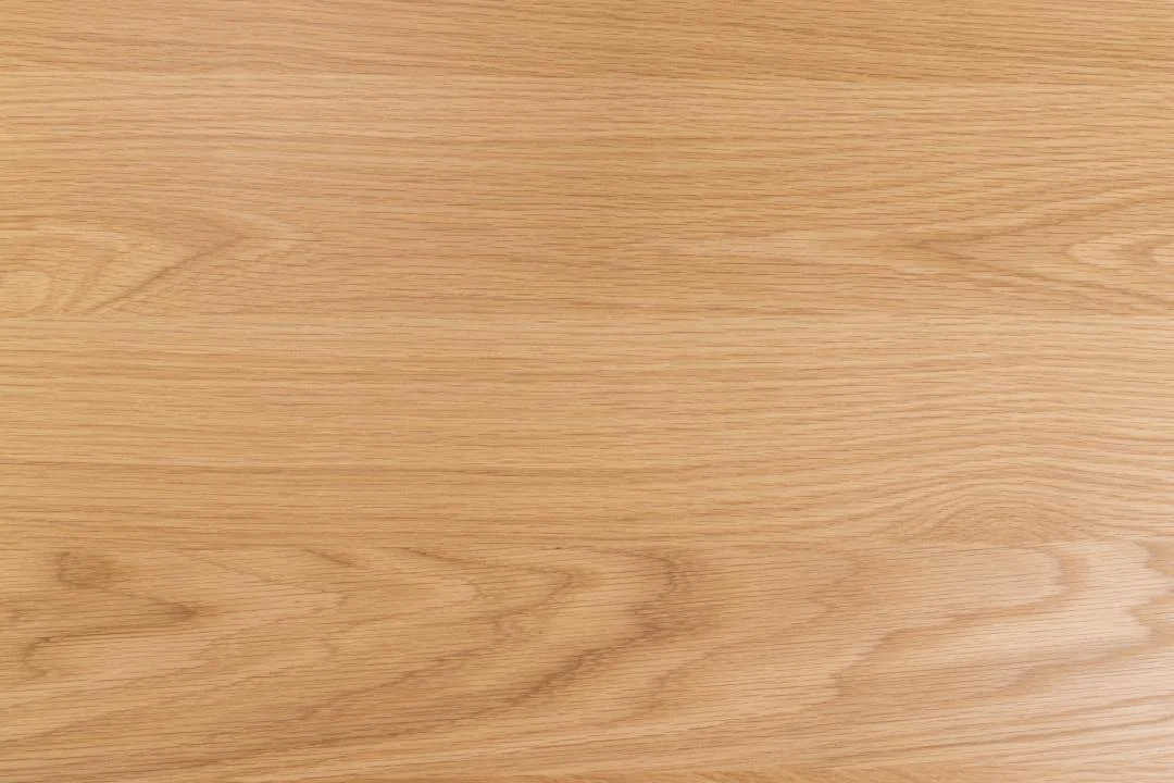 De Eettafel Nieuwe Sfeer 219 x 90 CM Rond heeft een glad, lichtgekleurd eiken oppervlak met zichtbare natuurlijke nerfpatronen die horizontaal lopen.