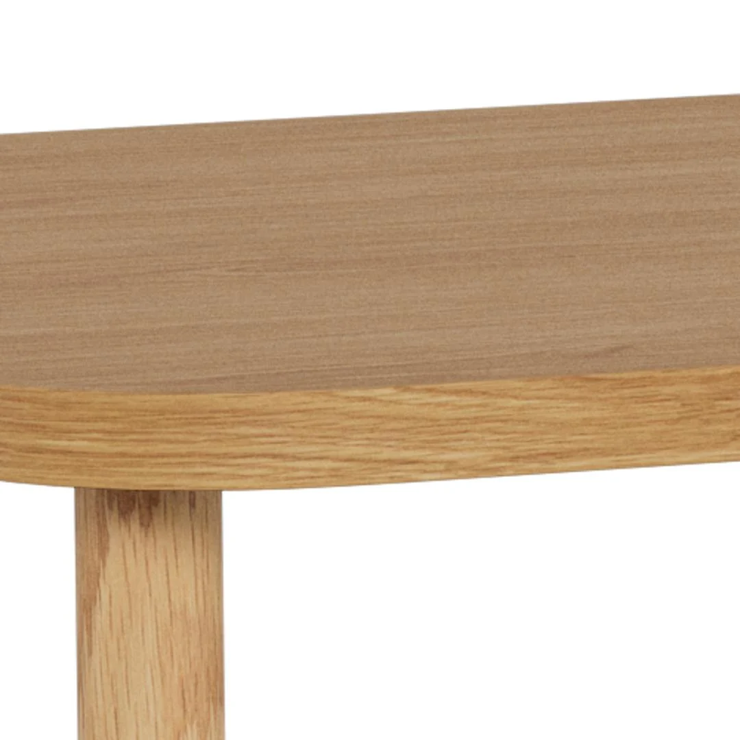 Close-up van de Salontafel Roest (134 x 34 cm rond) in licht eikenfineer, met de afgeronde rand, één zichtbare poot en gladde natuurlijke afwerking.