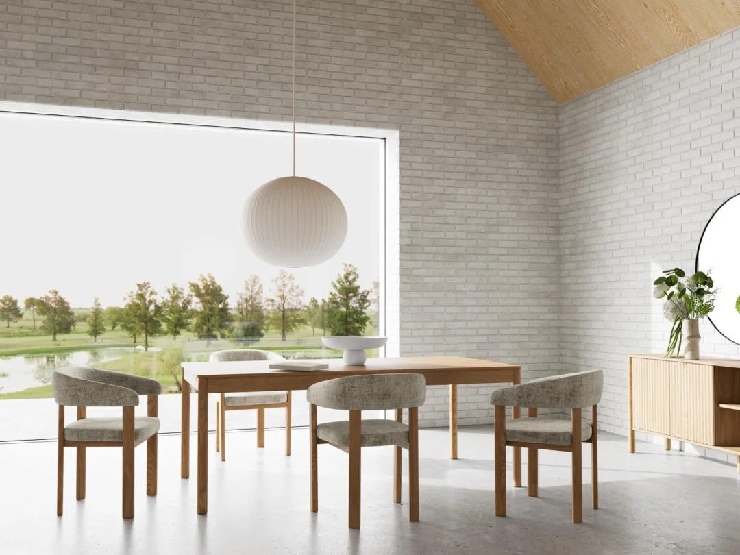 Minimalistische eetkamer met de Eettafel Nieuwe Sfeer 100 x 75 CM Rond in eikenhout, vier gestoffeerde stoelen, een grote ronde hanglamp, dressoir met bloemenvaas, ronde spiegel en een raam met uitzicht op de tuin.