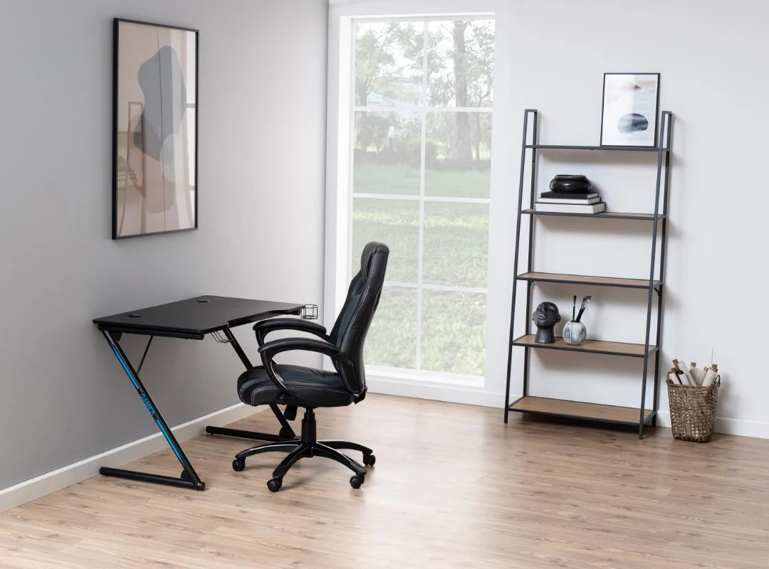 Minimalistisch thuiskantoor met een zwart bureau en bureaustoel bij een groot raam, muurkunst boven het bureau en een Seaford boekenkast met decoratieve items op een lichte houten vloer.