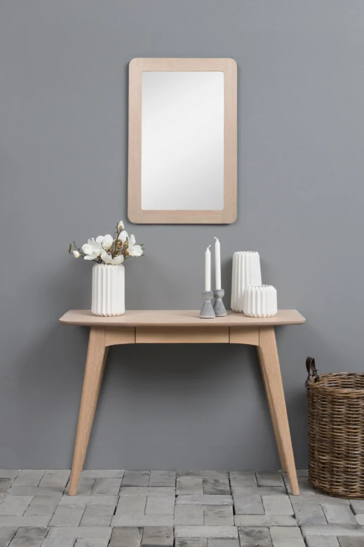 Houten kantoor bureau met spiegel, vazen en kaarsen. Stijlvol en functioneel.