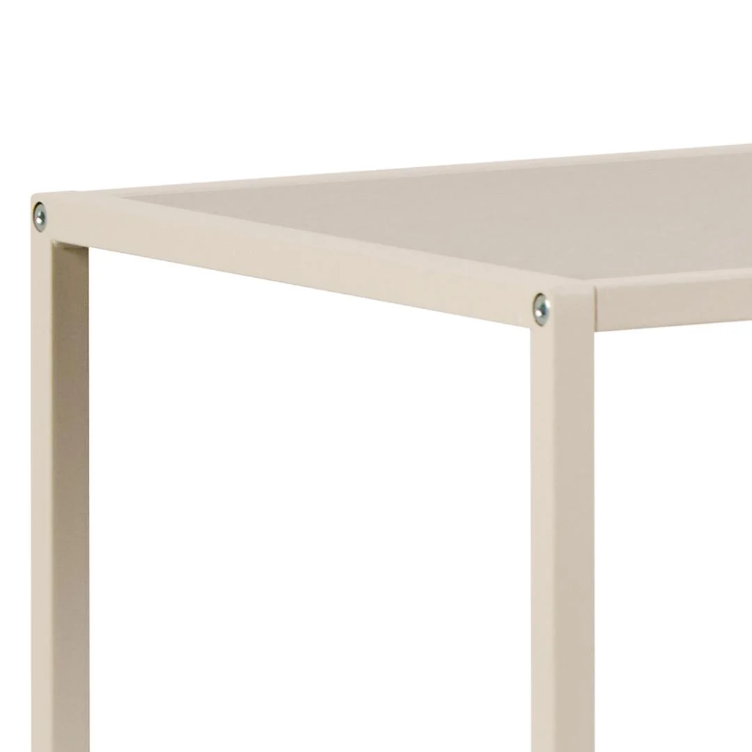 Close-up van de hoek van de Seaford boekenkast, een minimalistische, lichtbeige metalen boekenkast met een rechthoekig blad en zichtbare schroeven bij de verbindingen.