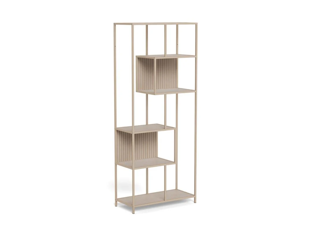 De Seaford boekenkast is een hoge, moderne beige kast met een open metalen frame, asymmetrische planken, twee doosvormige delen met verticale groeven en staat op vier slanke poten.