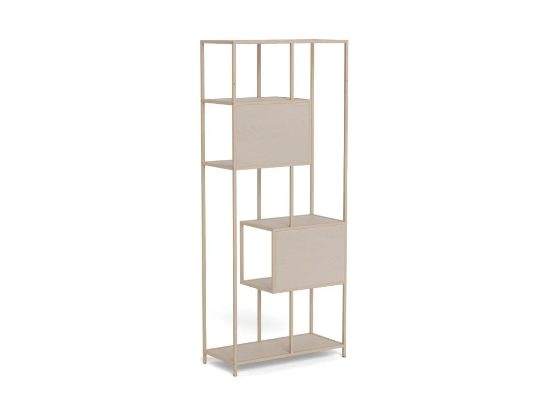 De Seaford boekenkast is een hoge, rechthoekige kast van licht hout met open vakken en twee gesloten compartimenten in een verspringend ontwerp, met een minimalistisch frame van dunne verticale en horizontale steunen.