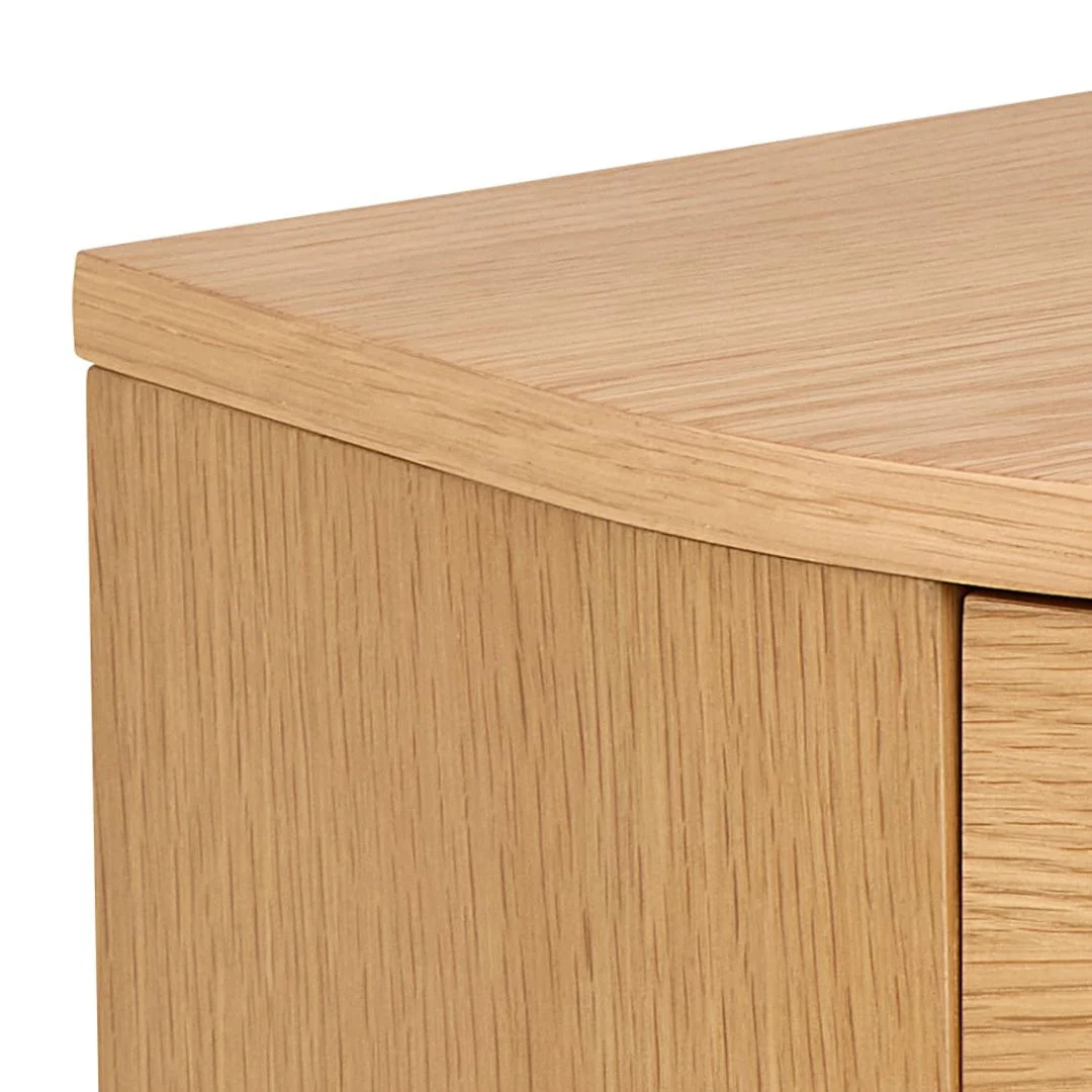 Close-up van de bovenste hoek van het Nachtkastje Eikenhout Slaapkamer, met een gladde, gebogen rand en natuurlijke eiken houtnerf afwerking.