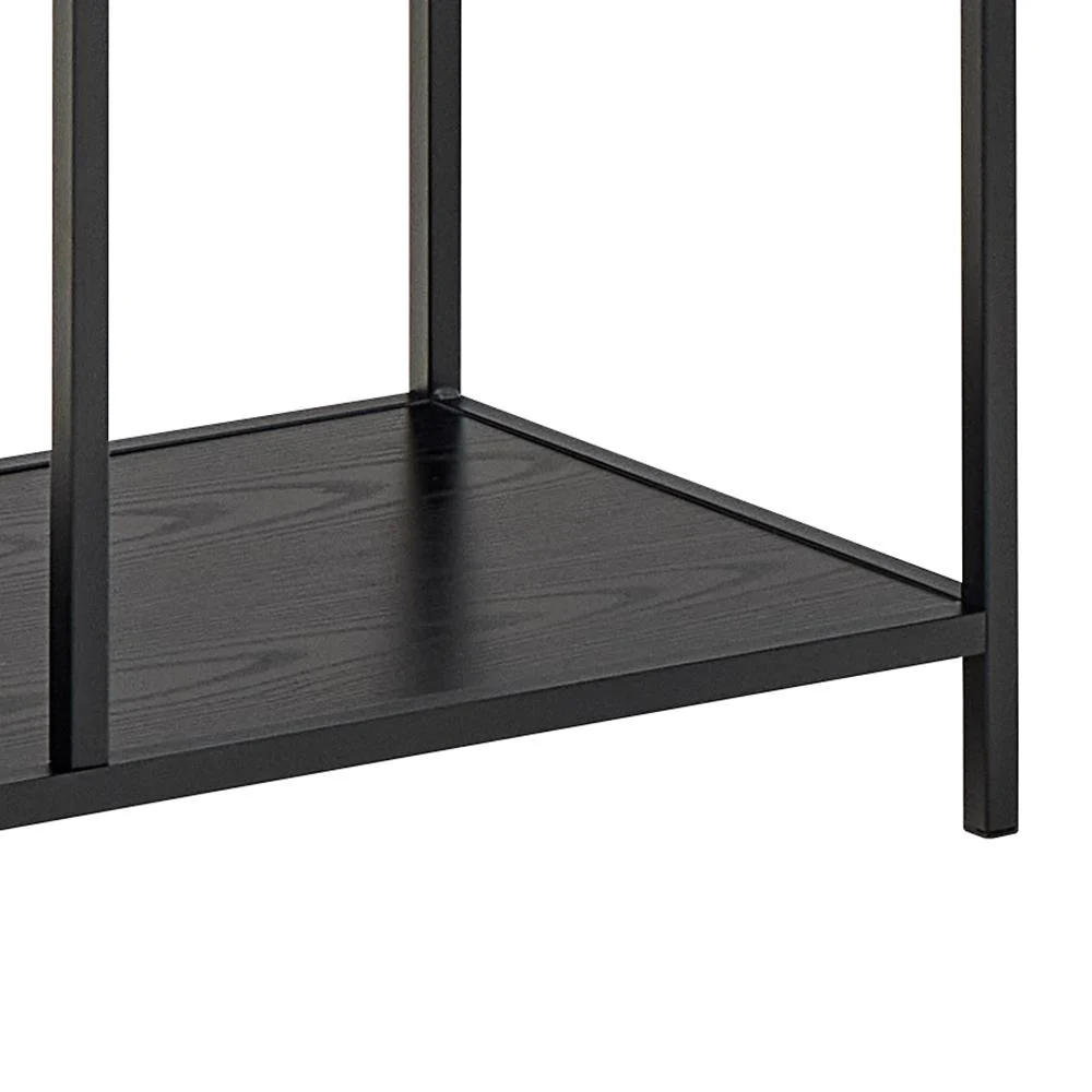 Een close-up van de onderste plank van de Seaford boekenkast benadrukt het zwarte metalen frame en het houten oppervlak.