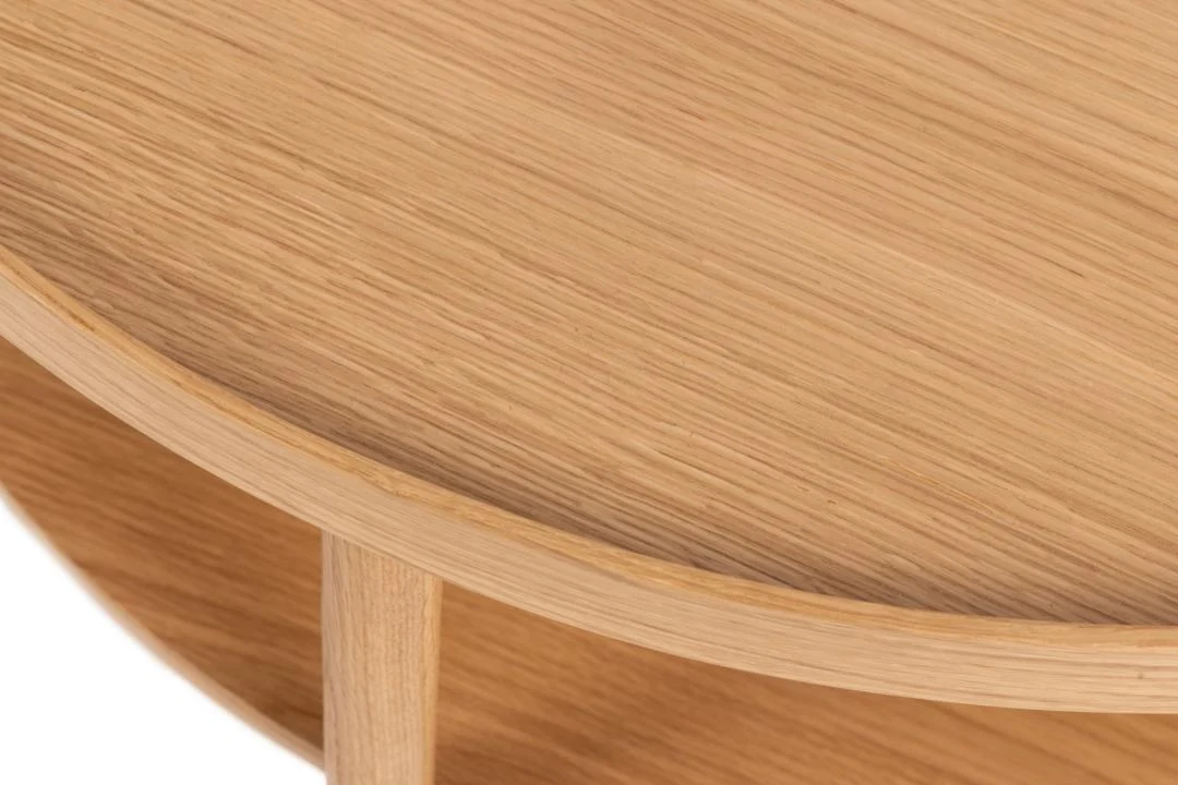 Close-up van de Salontafel Roest 80 CM Rond Eikenfineer, met de nadruk op het tafelblad in licht eikenfineer, de zichtbare houtnerf, de afgeronde rand en een deel van de poot met onderplank.