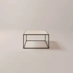 De Salontafel Zwart Ontwerp is een minimalistische vierkante salontafel met een dun zwart metalen frame en een licht tafelblad, getoond tegen een effen, lichte achtergrond.