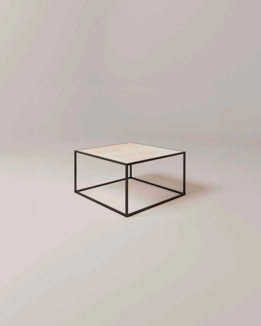 De Salontafel Zwart Ontwerp is een minimalistische vierkante salontafel met een dun zwart metalen frame en een lichtgekleurd plat blad tegen een effen, neutrale achtergrond.