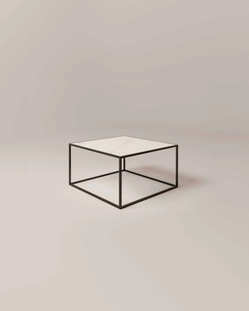 De Salontafel Zwart Klassiek Design heeft een minimalistische vierkante vorm met een dun frame van zwart metaal en een blad van wit marmer tegen een eenvoudige, lichte achtergrond.