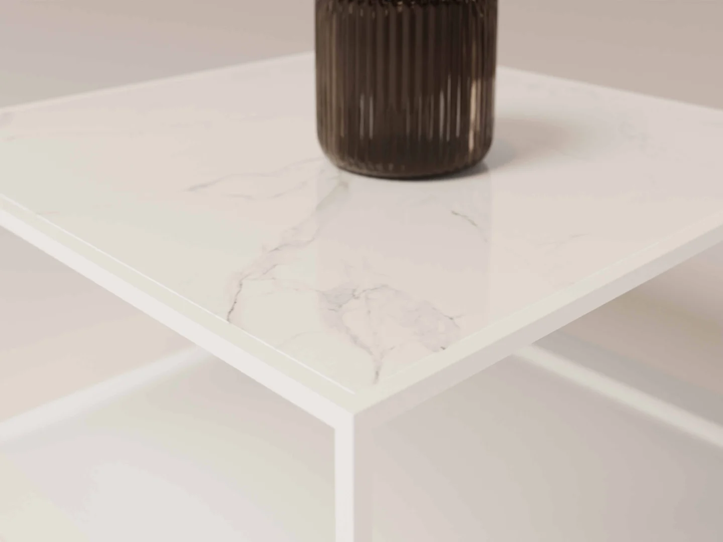 Een close-up van de Salontafel Wit Design Tijdloos Woonkamer toont het wit marmeren tafelblad met subtiele grijze adering. Een geribbelde, donkerbruine glazen vaas staat in een hoek, terwijl de zacht vervaagde achtergrond de tijdloze stijl benadrukt.