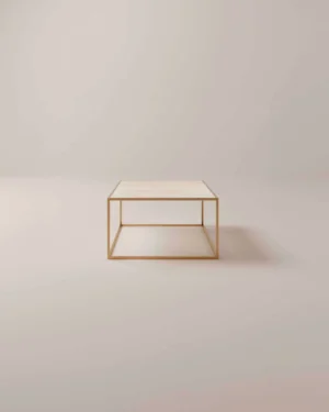 De Salontafel Messing, Roest heeft een minimalistisch ontwerp met een licht rechthoekig blad en een slank goud metalen frame, tegen een neutrale lichtbeige achtergrond.