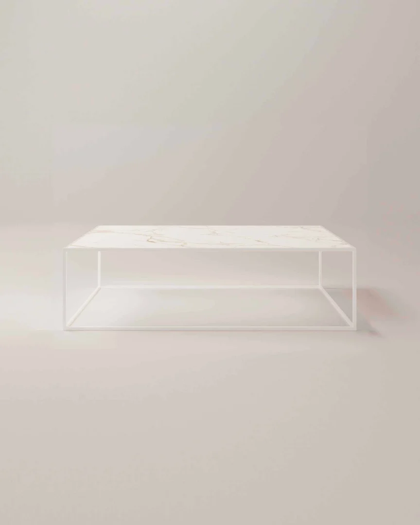 De Salontafel Wit Industrieel is een moderne, minimalistische rechthoekige salontafel met een wit marmeren blad en een open wit metalen frame, tegen een lichte, neutrale achtergrond.
