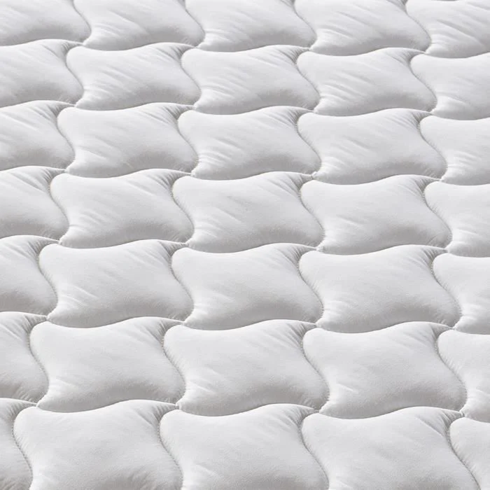 Detailopname van een wit matras 90 x 190 met comfortzones. Het zachte materiaal is gelijkmatig verdeeld, met subtiele stiksels. Heldere belichting.