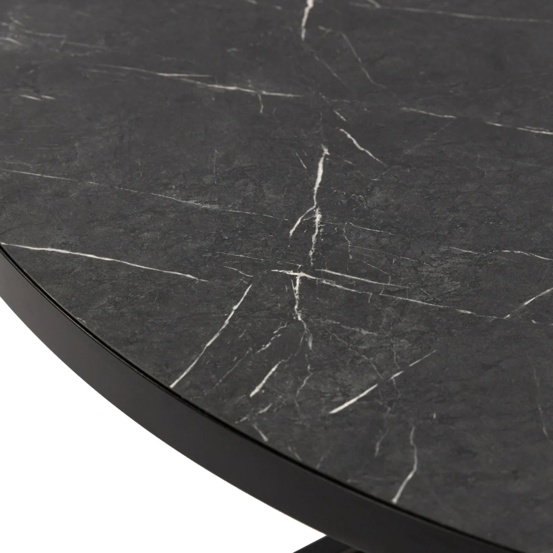 Een close-up van de Stalux Ronde eettafel 'Daan' 120cm in zwart/zwart marmer, met de nadruk op het gladde zwart marmeren tafelblad met natuurlijke witte adering.