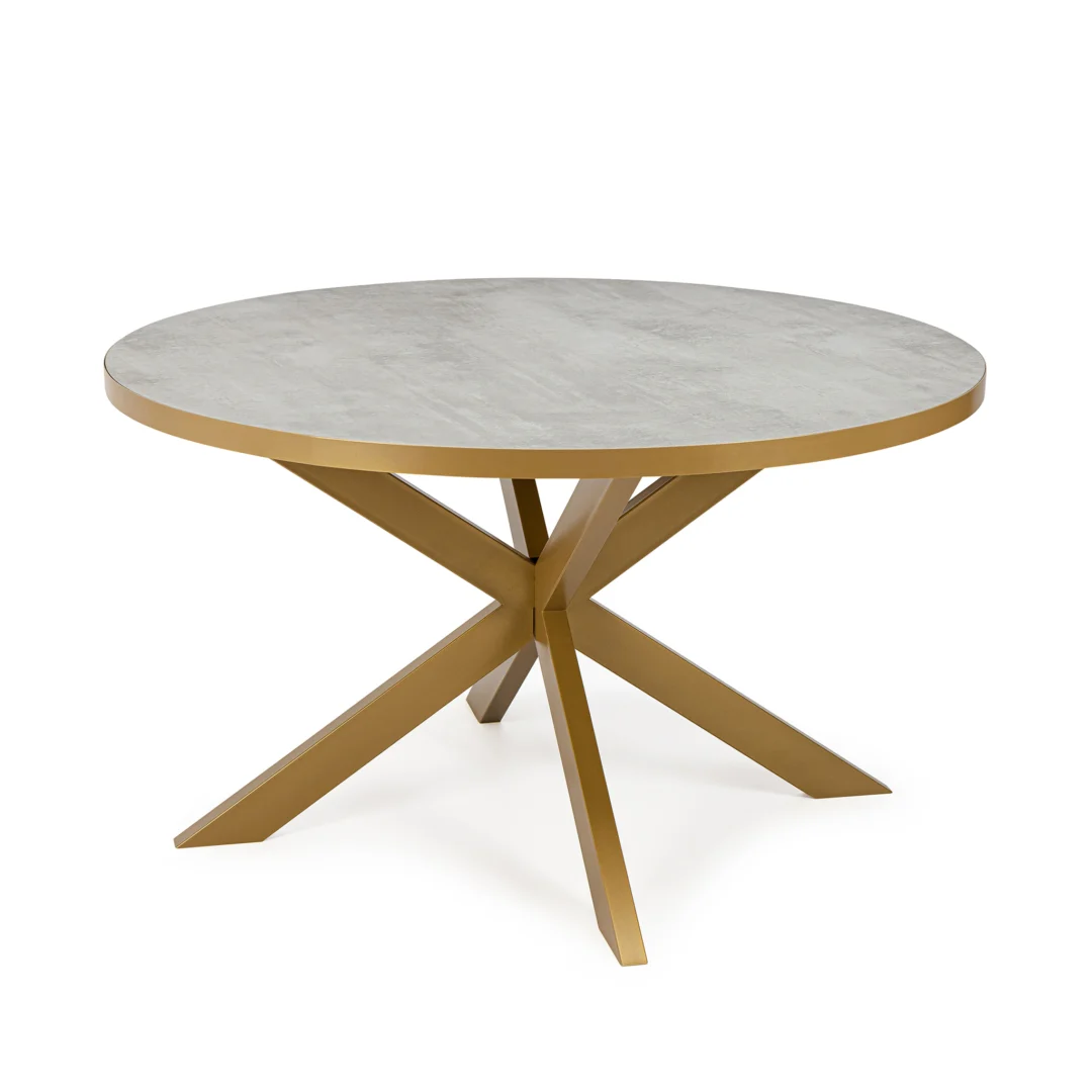De Stalux Ronde eettafel 'Daan' 120cm heeft een lichtgrijs (beton) rond tafelblad en een modern gouden onderstel met vier schuine poten die in het midden samenkomen.