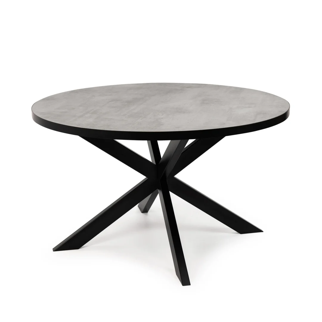 De Stalux Ronde eettafel 'Daan' (135cm) heeft een grijs betonnen blad en een modern zwart onderstel met vier schuine poten die elkaar in het midden kruisen.