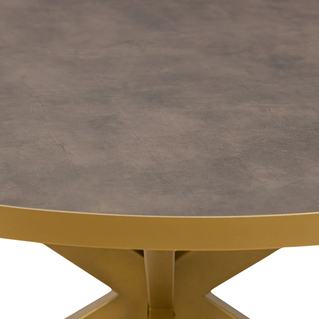 Een close-up van de Stalux Ronde eettafel 'Daan' (148cm) met een goudkleurige basis en rand, en een bruine lederlook ronde bovenkant, getoond tegen een witte achtergrond.