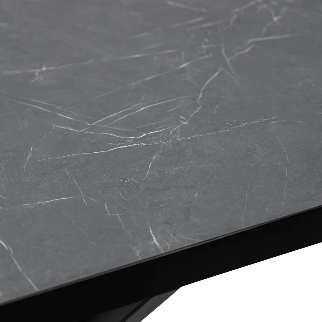 Close-up van de Stalux Plat ovale eettafel 'Noud' (210 x 100), met een donkergrijs tafelblad met subtiele witte marmeren adering, op een zwart onderstel. Kleur: zwart/zwart marmer.