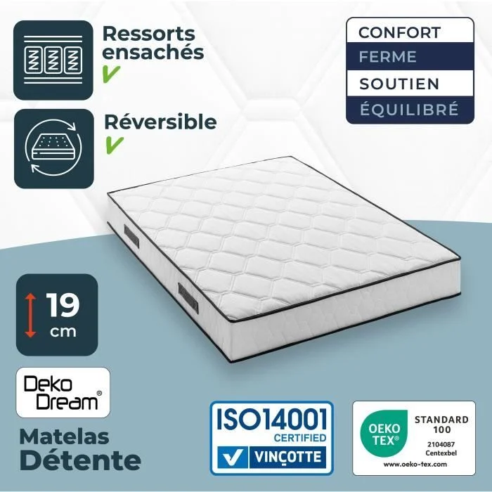 Witte boxspring matras met zwarte rand, schuin van voren gezien. Certificaten en logo's in beeld. Zachte belichting.