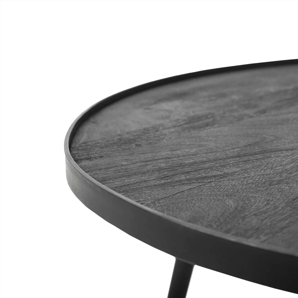 Close-up van de rand van de Salontafel Zwart 76 x 44 CM Rond, een ronde, donkerhouten tafel met een opstaande rand, tegen een effen witte achtergrond.