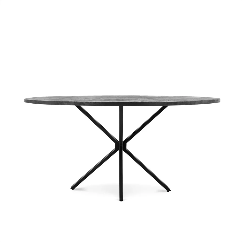 De Eettafel Rond Yana Zwart 140 is een moderne ronde tafel met een donker plat tafelblad en een zwart metalen onderstel met vier schuine poten die elkaar in het midden kruisen, tegen een effen witte achtergrond.