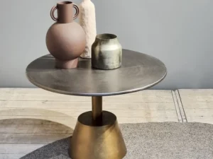 De Sidetable Kian Goud Zilver, met een koperen onderstel, toont drie aardegekleurde vazen - een ronde met handgrepen, een hoge met textuur en een korte met metallic - tegen een neutrale achtergrond en deels op een grijs vloerkleed.