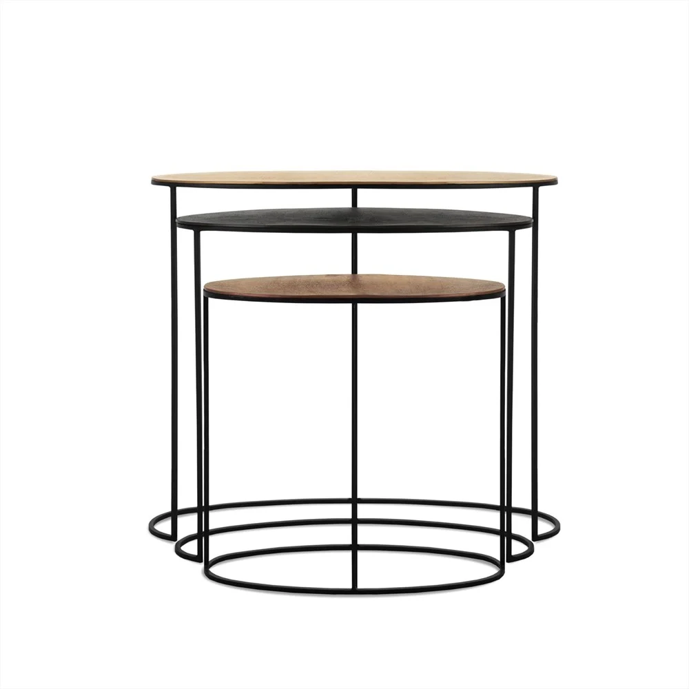 De Sidetable Emily Set van 3 bestaat uit ronde nesttafels met slanke zwarte metalen frames en houten bladen, ontworpen in een moderne minimalistische stijl. De tafels passen netjes onder elkaar voor handige opslag op een witte achtergrond.