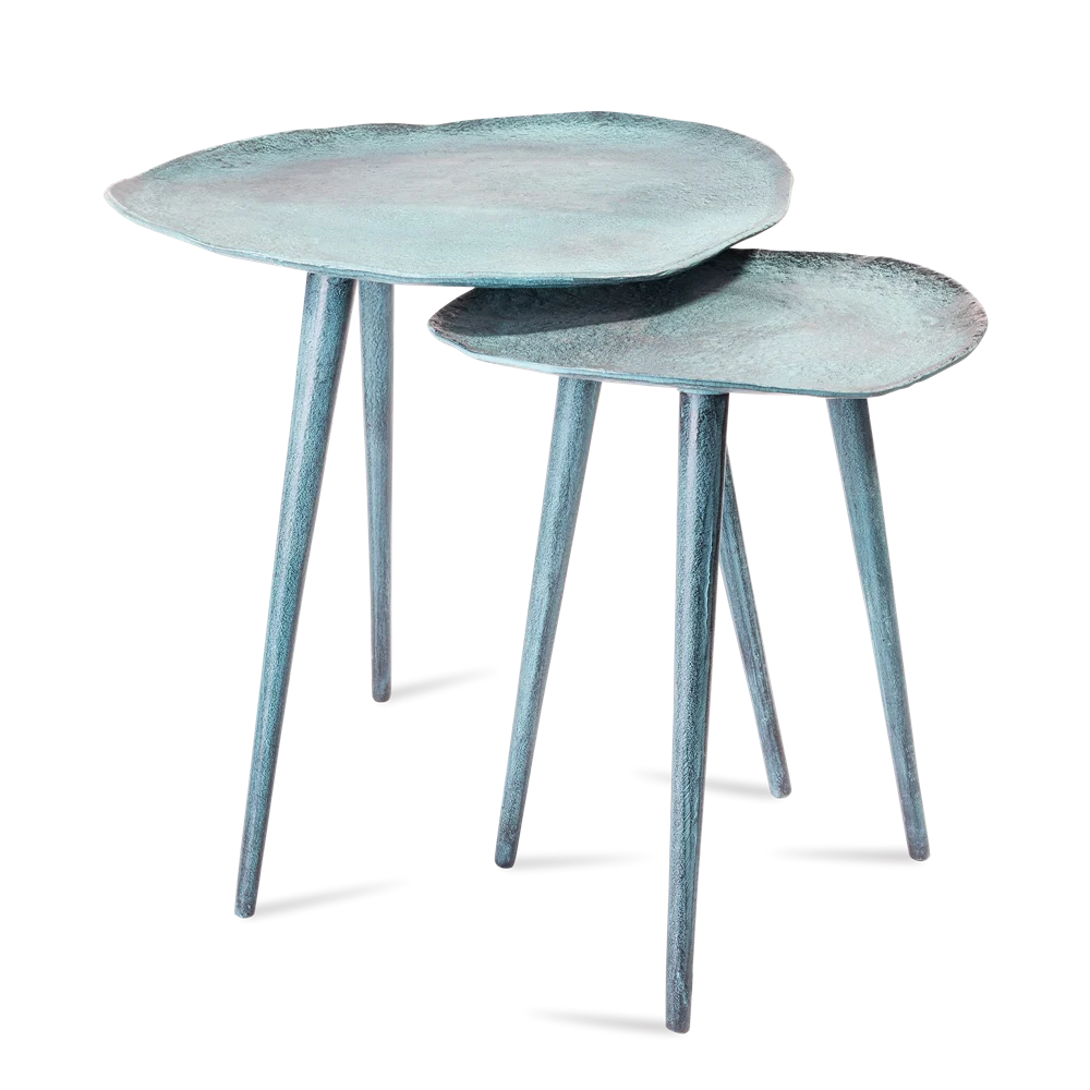 De Sidetable Blauw Patina 34,5 (set van 2) bestaat uit twee moderne nesttafels met lichtblauwe, gestructureerde, onregelmatige tafelbladen en elk drie slanke poten, samen getoond op een witte achtergrond.