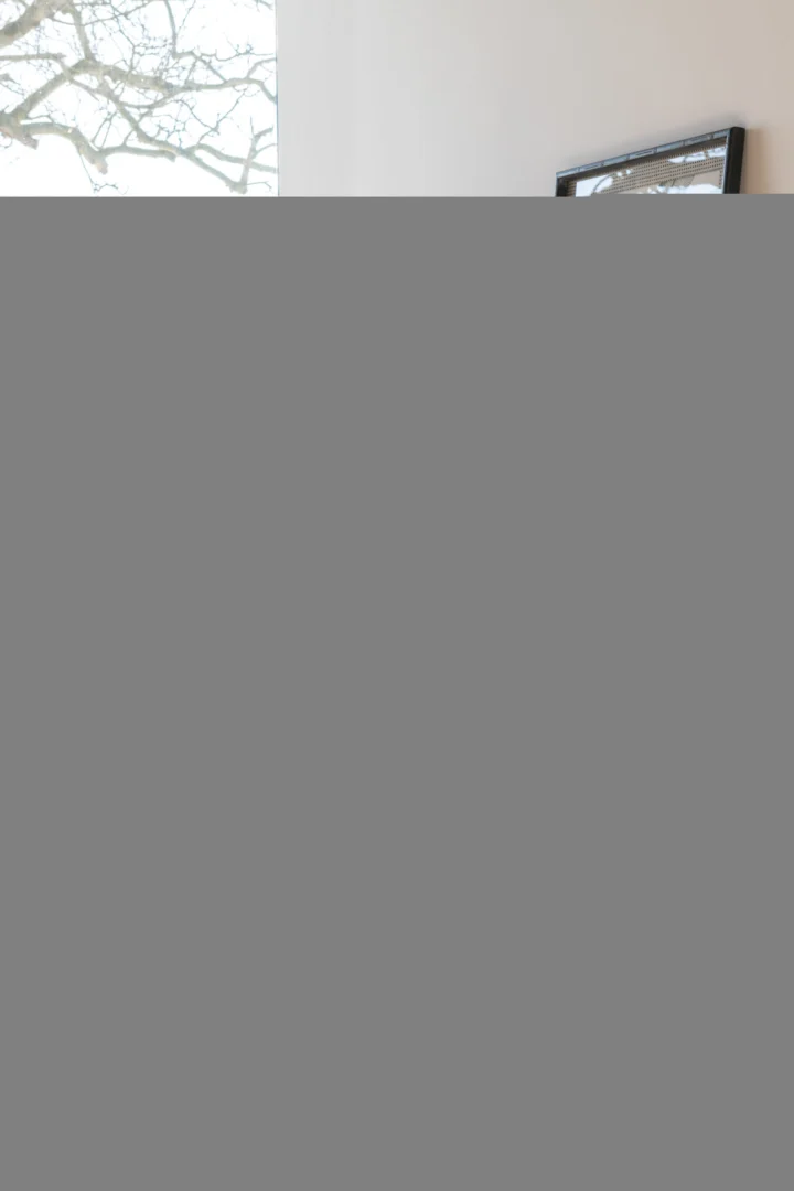 Detailopname van een industrieel bureau van eikenhout en metaal in naturel en zwart.