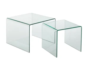 De Bijzettafel Transparant 65 x 65 CM bestaat uit twee vierkante nesttafels van helder glas met metalen frame en gebogen randen, één groter en één kleiner, naast elkaar op een witte achtergrond.