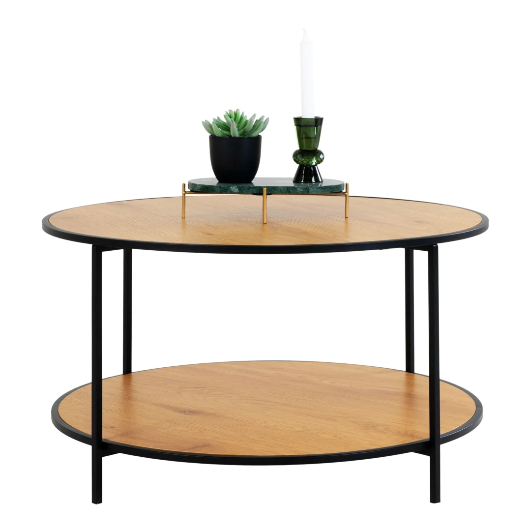 De Salontafel Roest (80 x 45 CM, rond) is een ronde salontafel gemaakt van spaanplaat, met zwart metalen poten en een onderste plank. Op het tafelblad staat een vetplant in pot, een groene kandelaar met witte kaars en een groen rechthoekig dienblad.