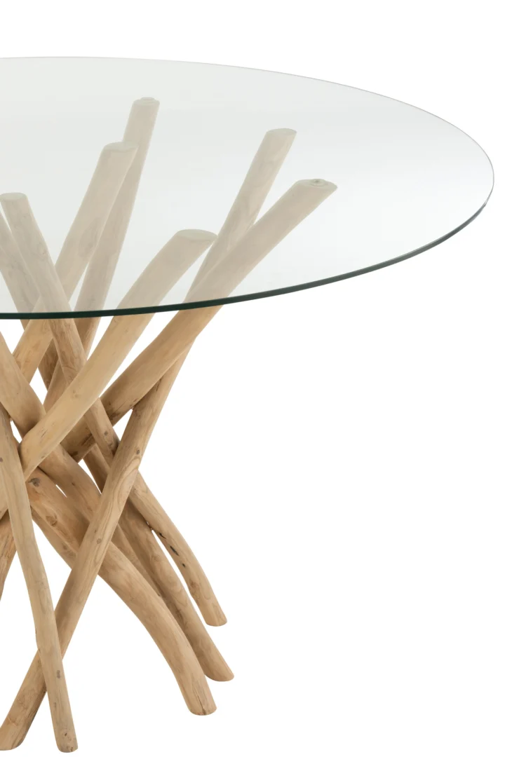 De Eettafel Branches Rond Teakhout Natuurlijk/Glas heeft een rond glazen tafelblad dat wordt ondersteund door een licht teakhouten takken onderstel, tegen een witte achtergrond.