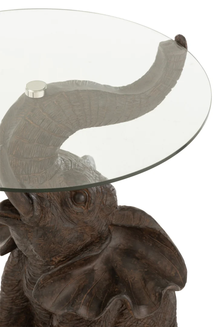 De Bijzettafel Bruin 63 CM Glas heeft een gebeeldhouwde donkere olifant met een verhoogde slurf die een rond glazen blad ondersteunt.