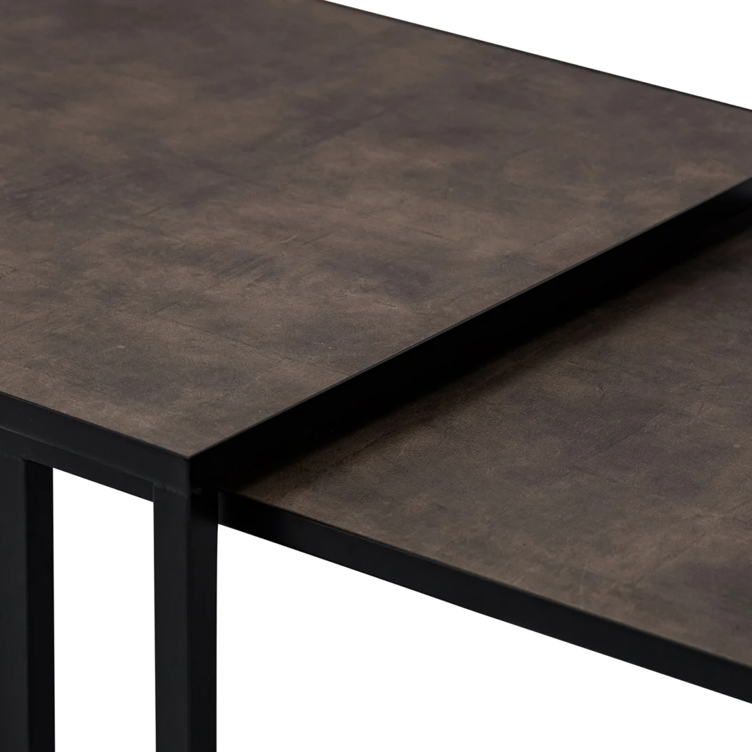 Een close-up van Salontafel Zwart, Bruin (67 x 44 cm) toont twee in elkaar overlopende tafelbladen met bruine structuur en zwarte metalen frames in een modern, minimalistisch ontwerp. De oppervlakken zijn licht mat.